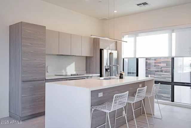 a kitchen with stainless steel appliances a sink and a refrigerator