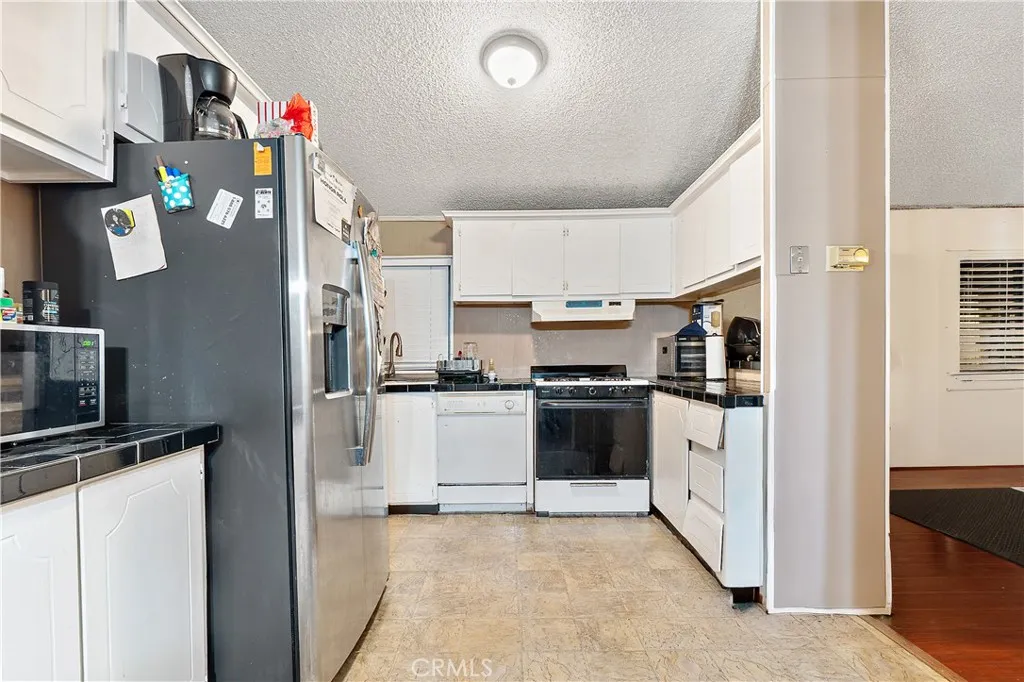 1051 Site, Unit 251 Brea, CA 92821 - Photo 11 of 23 a kitchen with stainless steel appliances and white cabinets
