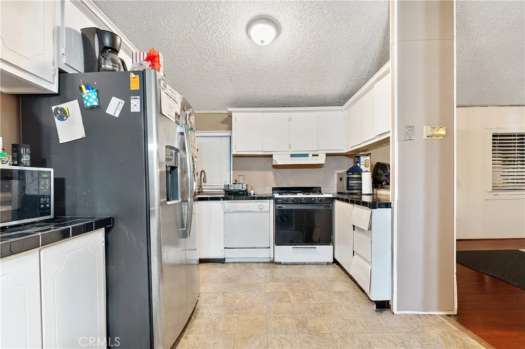1051 Site, Unit 251 Brea, CA 92821 - Photo 11 of 23 a kitchen with stainless steel appliances and white cabinets