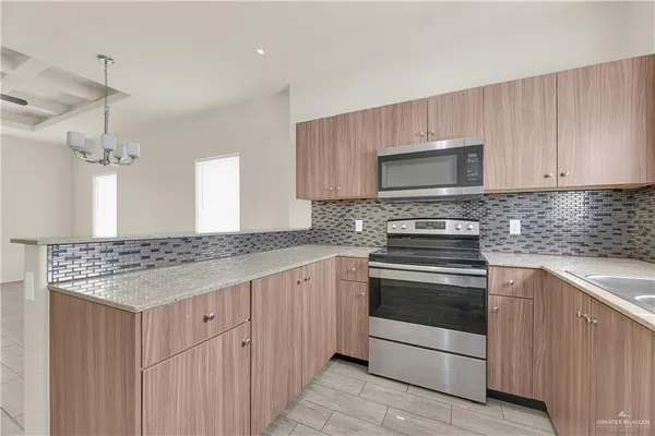a kitchen with stainless steel appliances granite countertop a stove and a microwave