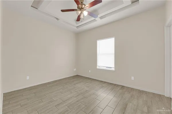 an empty room with a window and a fan