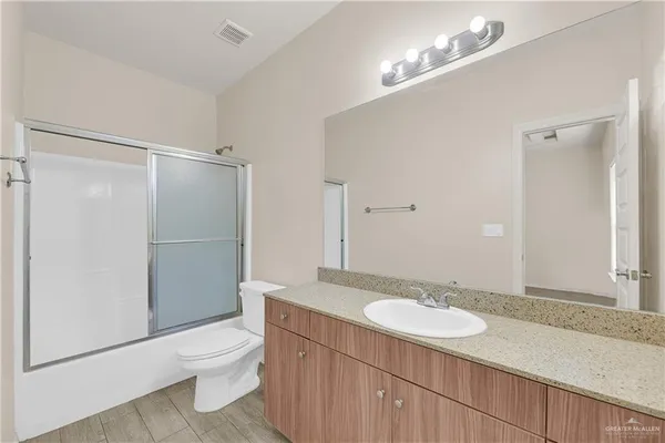 a bathroom with a sink toilet a mirror and shower