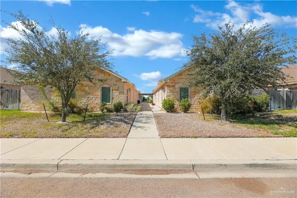 a view of a house with street that has a tree