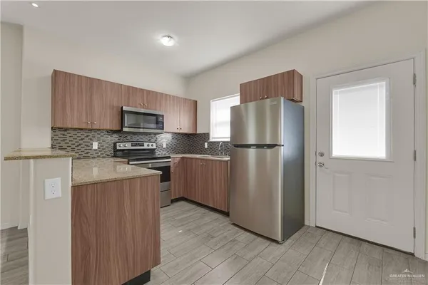 a kitchen with wooden cabinets and stainless steel appliances