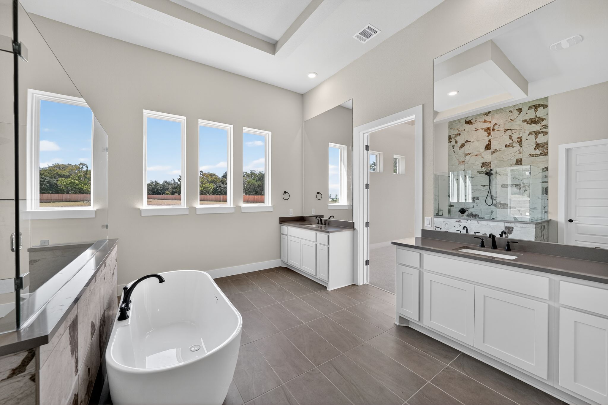 205 Three Rivers Road Georgetown, TX 78633 - Photo 14 of 32 a en suite bathroom with double vanity a mirror and a bathtub