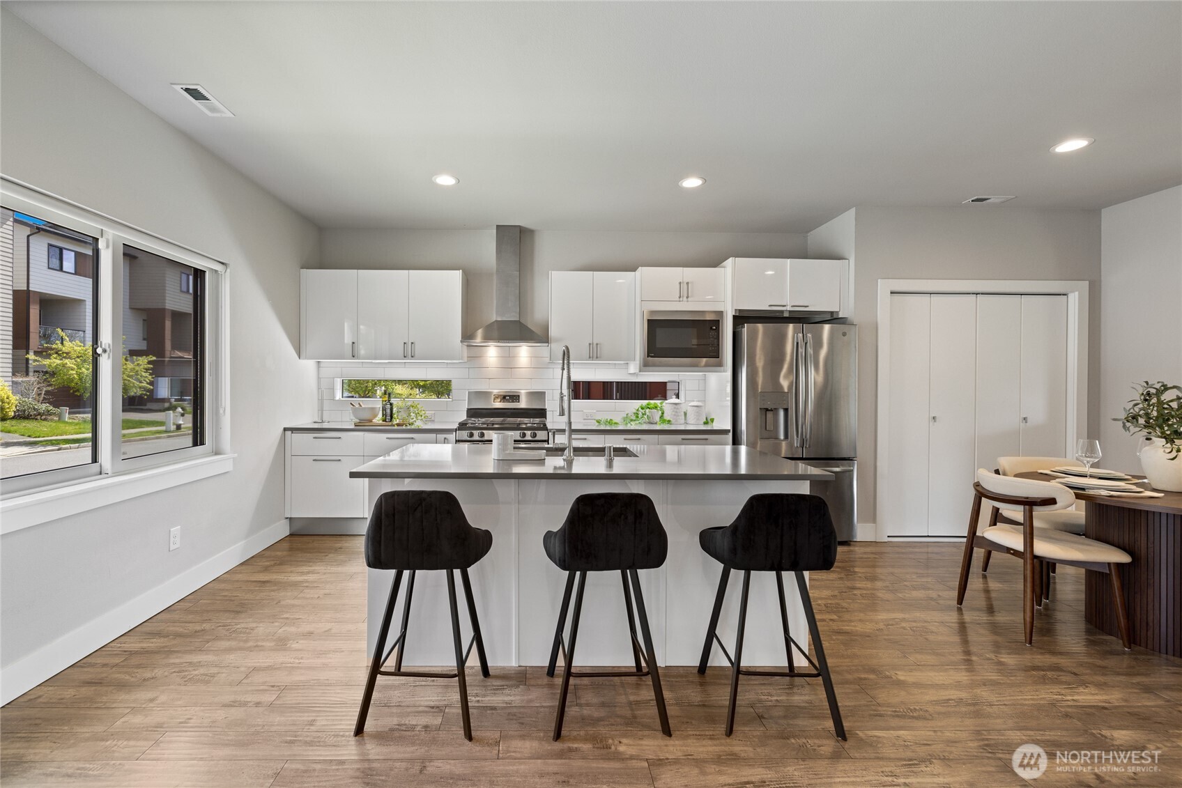 24903 123rd Place Southeast Kent, WA 98030 - Photo 3 of 40 a kitchen with stainless steel appliances kitchen island granite countertop a dining table chairs and granite counter tops