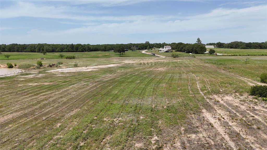 8605 West Highway 199 Springtown, TX 76082 - Photo 23 of 23 Expansive open land featuring a mix of green and dry vegetation, a distant body of water, and a tree line bordering the horizon