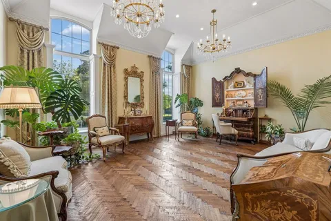 a living room with patio furniture and a chandelier
