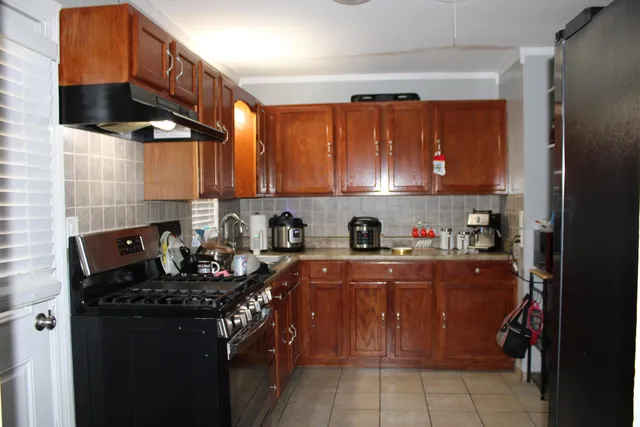 a kitchen with stainless steel appliances a stove a sink a refrigerator and cabinets