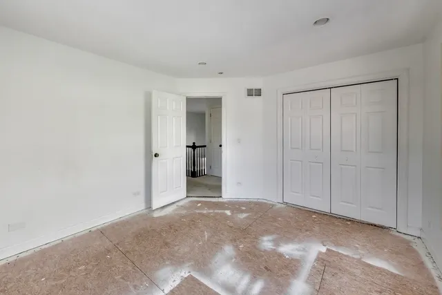 an empty room with an entryway and closet