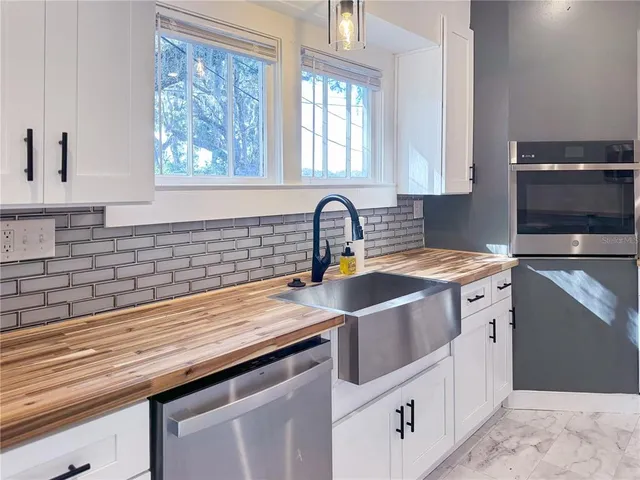 a spacious bedroom with a bed and wooden floor