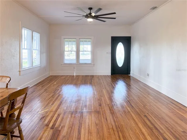 an empty room with wooden floor and a window