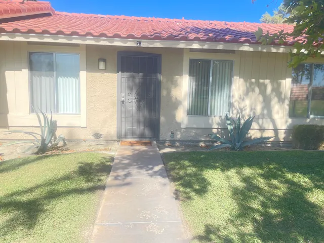 a front view of a house with a yard and a fountain