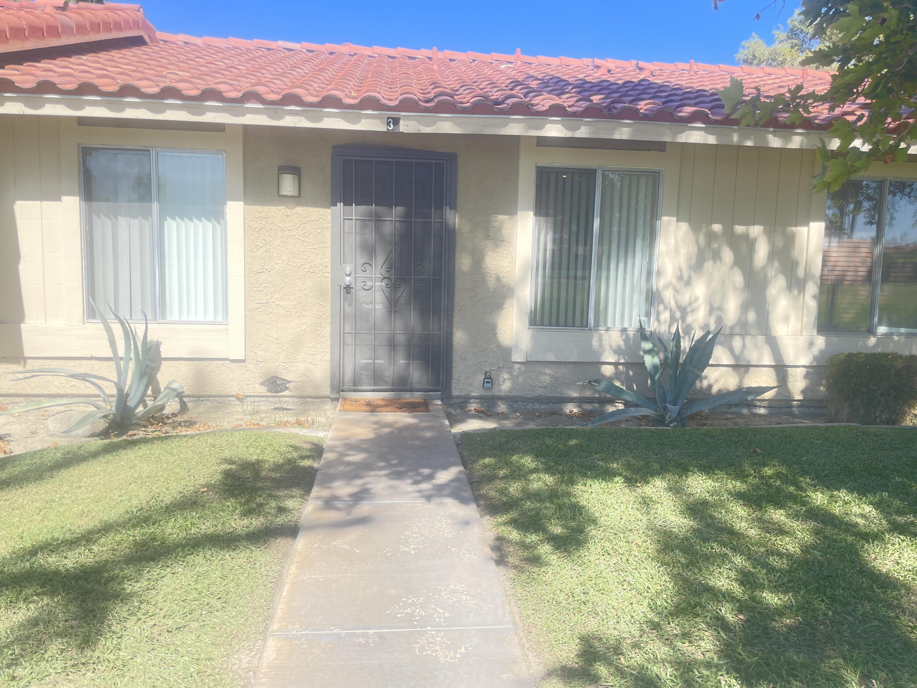 82567 Ave 48, Unit 36 Indio, CA 92201 - Photo 15 of 27 a front view of a house with a yard and a fountain