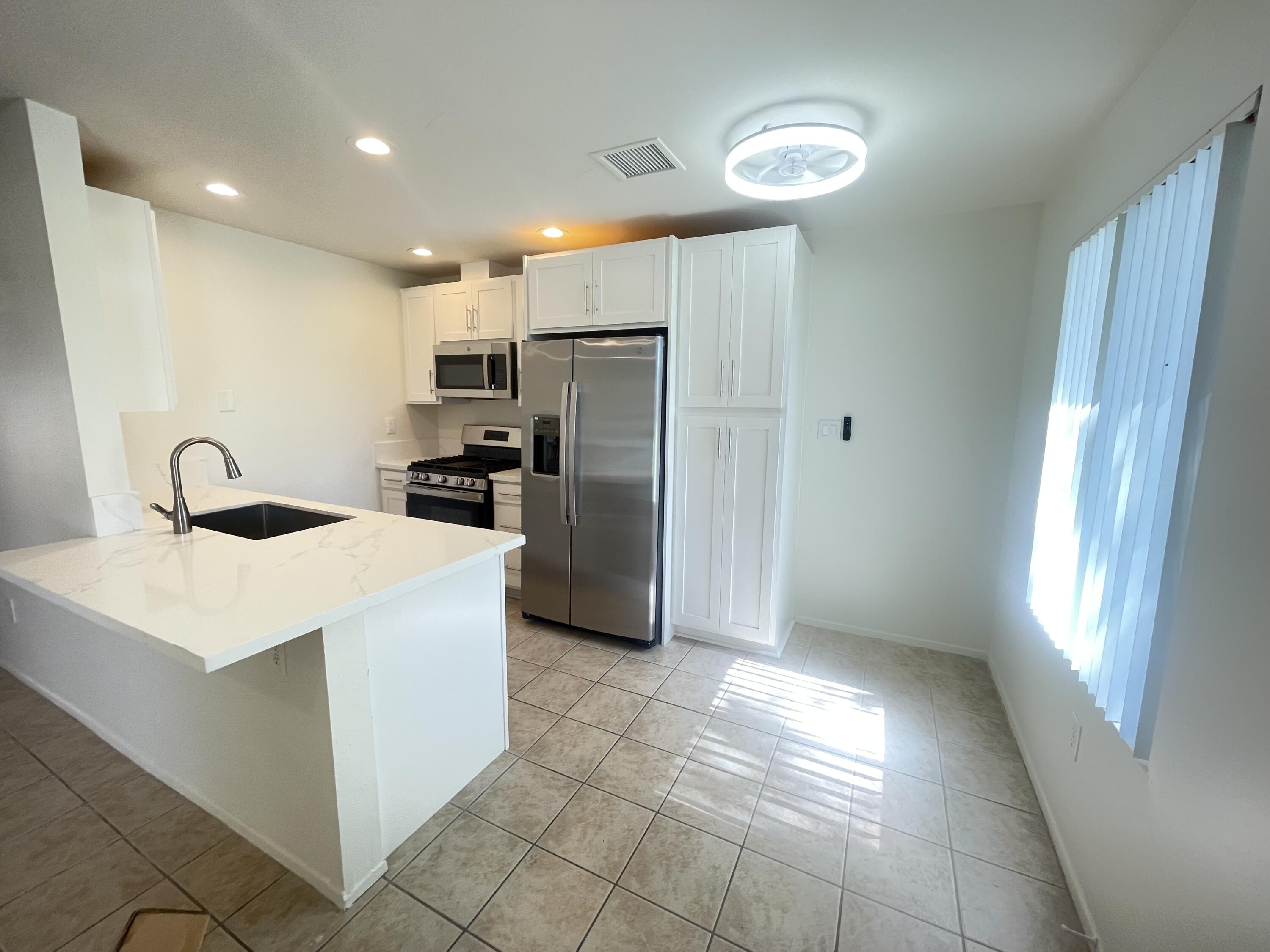 82567 Ave 48, Unit 36 Indio, CA 92201 - Photo 9 of 27 a kitchen with stainless steel appliances a refrigerator sink and microwave