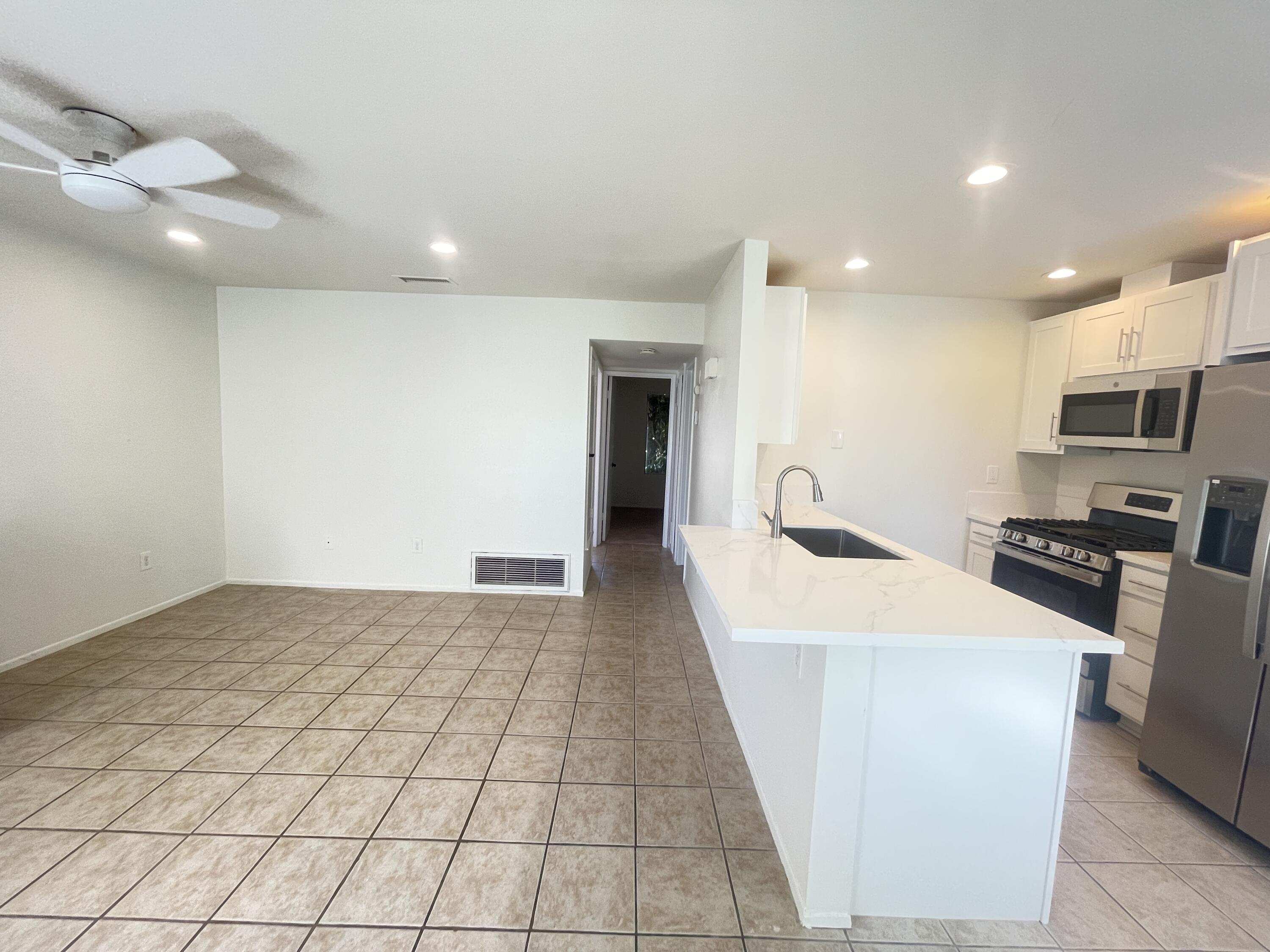 82567 Ave 48, Unit 36 Indio, CA 92201 - Photo 10 of 27 a kitchen with stainless steel appliances a refrigerator sink and microwave