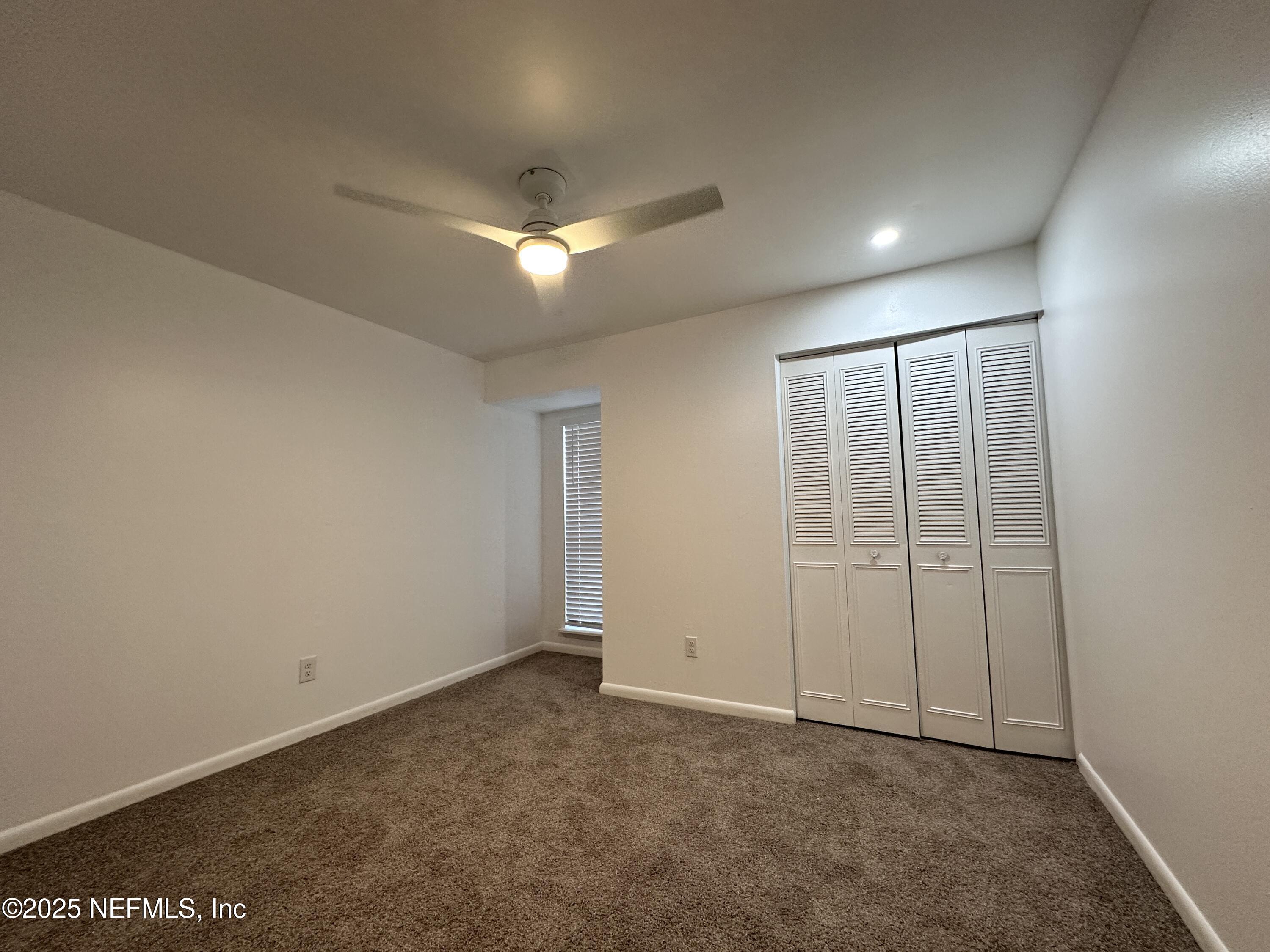 2538 Green Spring Drive Jacksonville, FL 32246 - Photo 12 of 15 an empty room with closet and a ceiling fan
