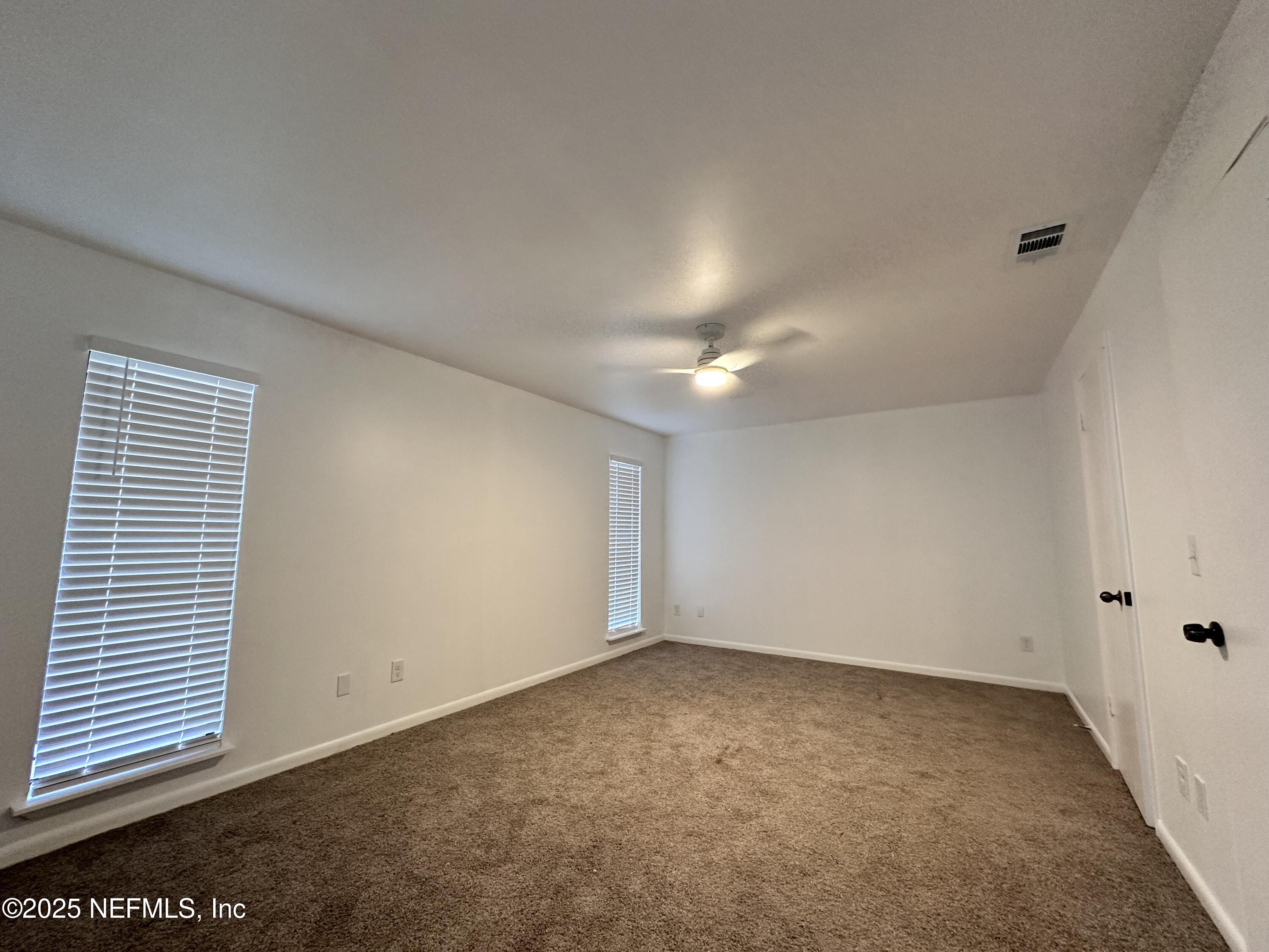 2538 Green Spring Drive Jacksonville, FL 32246 - Photo 8 of 15 an empty room with a ceiling fan and windows