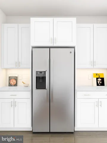 a view of a refrigerator in kitchen with stainless steel appliances wooden floor
