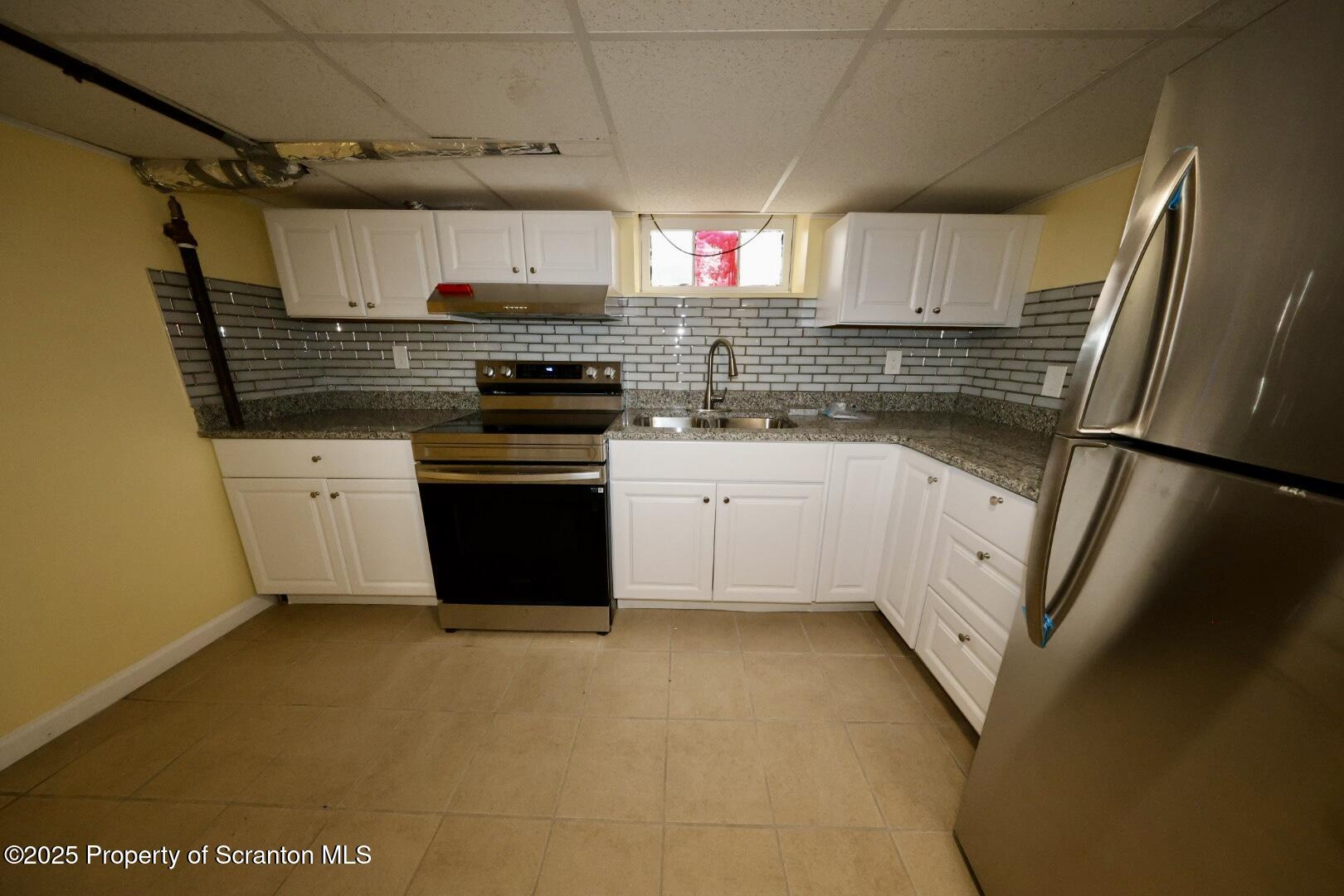 322 1st Street Olyphant, PA 18447 - Photo 3 of 13 a kitchen with stainless steel appliances granite countertop a refrigerator a sink dishwasher a stove and white countertops with wooden floor