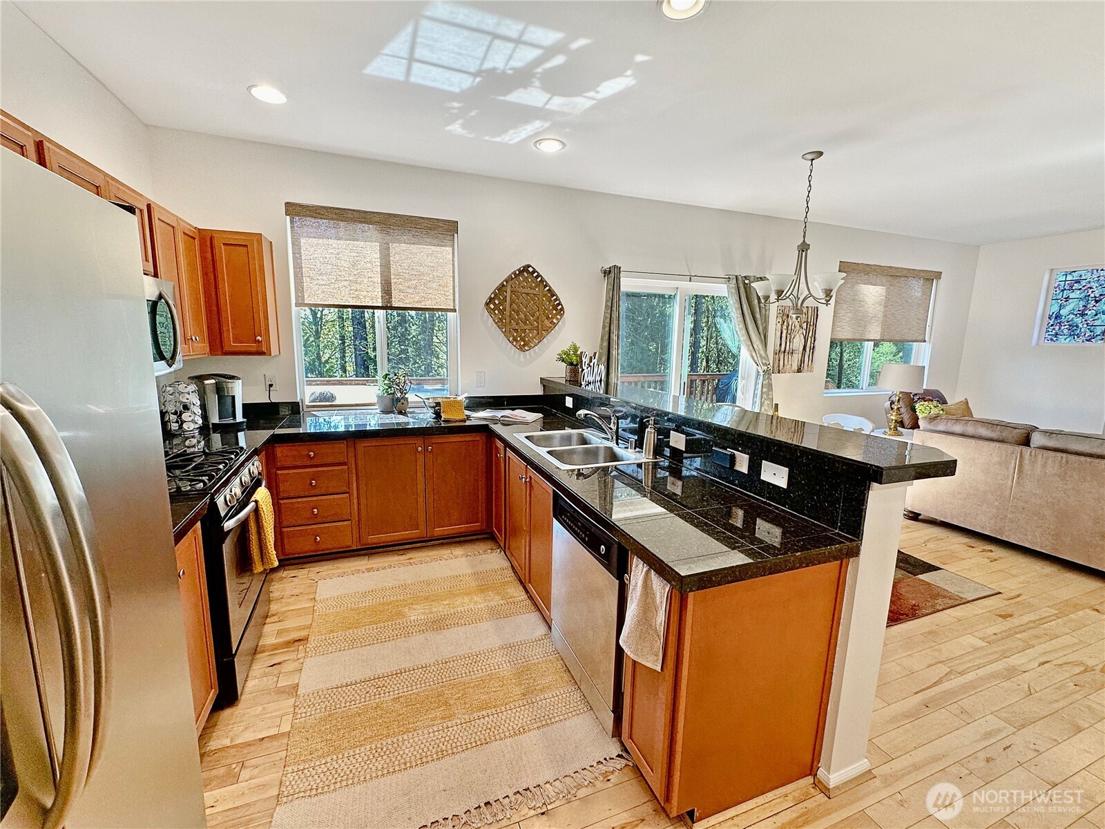 1348 Ebbets Drive Tumwater, WA 98512 - Photo 18 of 37 a kitchen with stainless steel appliances granite countertop a stove a sink dishwasher and a refrigerator