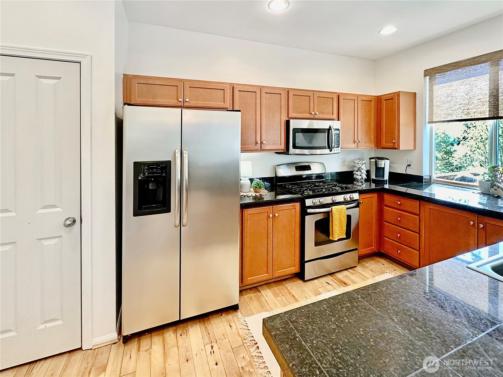 1348 Ebbets Drive Tumwater, WA 98512 - Photo 19 of 37 a kitchen with stainless steel appliances granite countertop a stove a sink dishwasher a refrigerator and a microwave