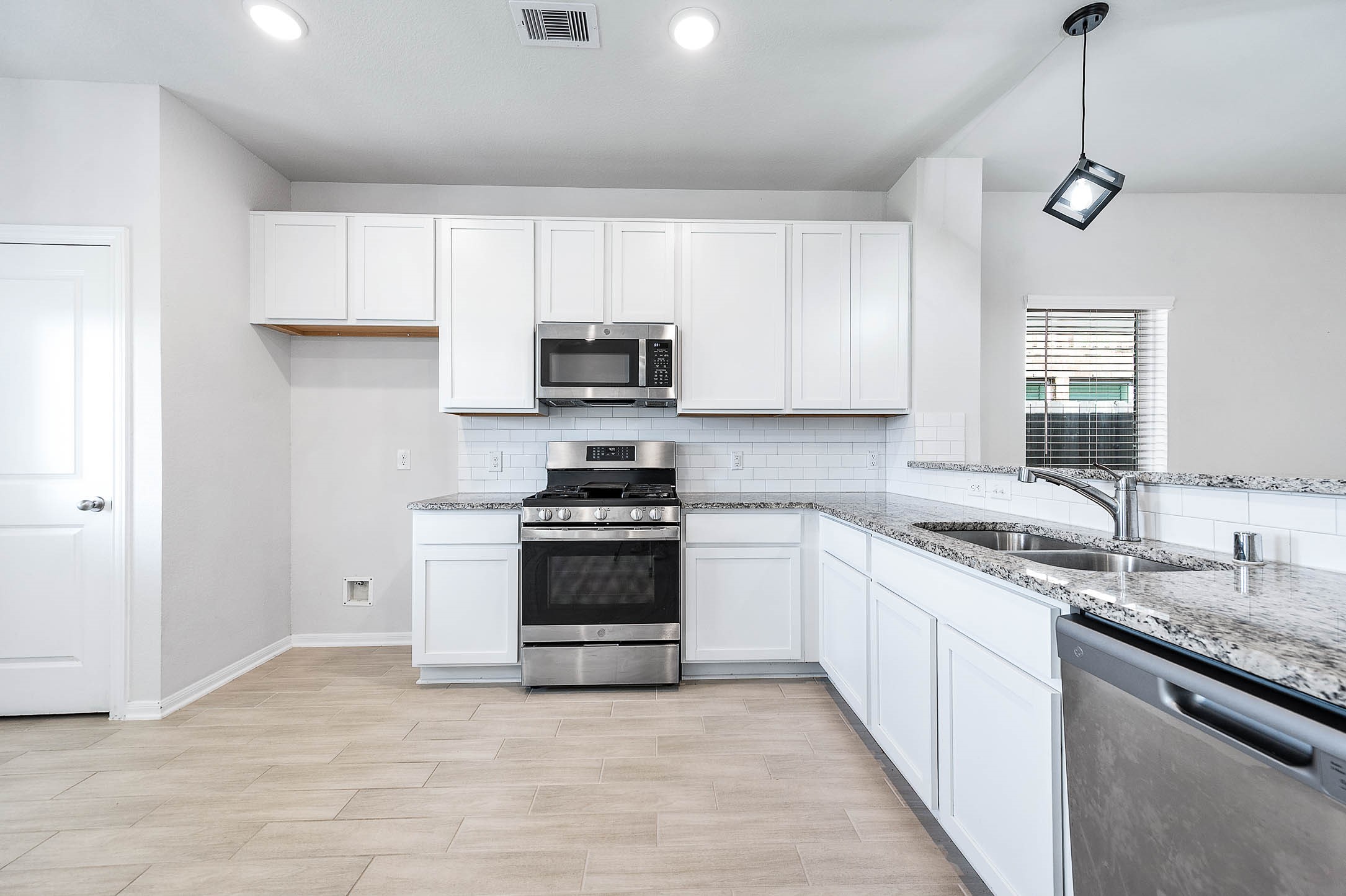 3611 Prairie Rose Trail Angleton, TX 77515 - Photo 12 of 25 a kitchen with stainless steel appliances granite countertop a sink a stove a refrigerator cabinets and a window