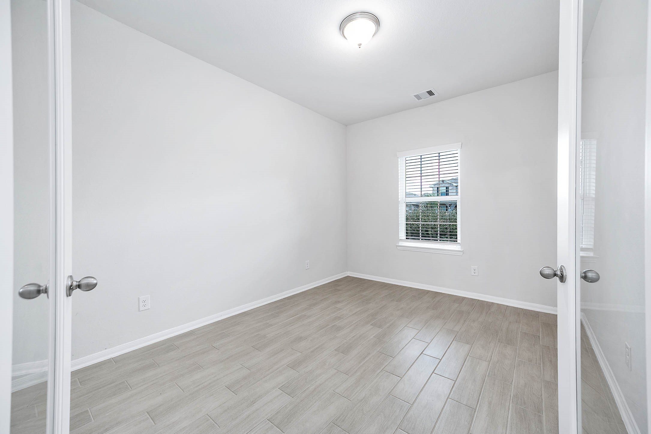3611 Prairie Rose Trail Angleton, TX 77515 - Photo 8 of 25 an empty room with wooden floor and a window