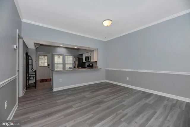 a kitchen with granite countertop a sink cabinets and wooden floor