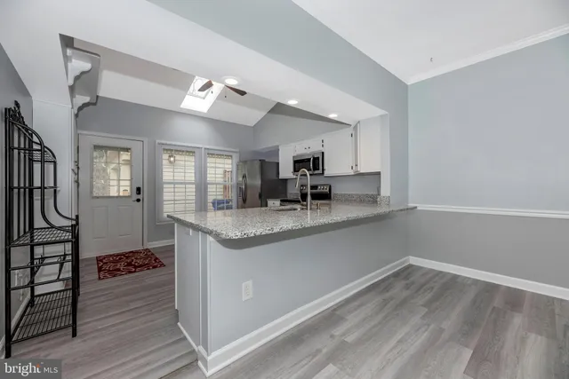 a kitchen with granite countertop a refrigerator and a stove top oven