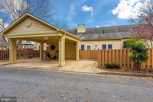 a view of a house with brick walls plants and large tree