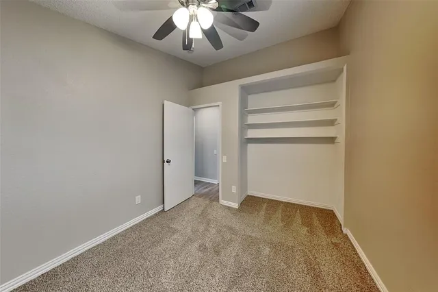 an empty room with a empty space and chandelier fan