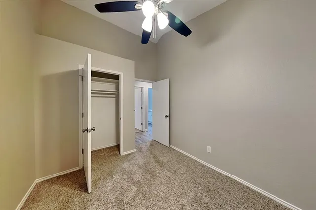 an empty room with a window and a fan