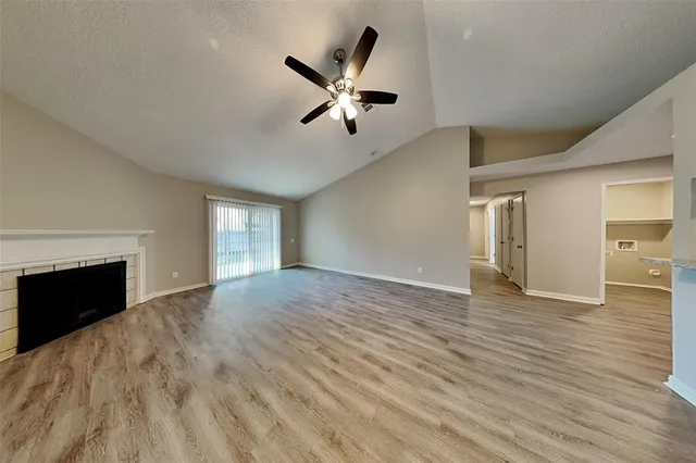 a view of empty room with wooden floor and fireplace