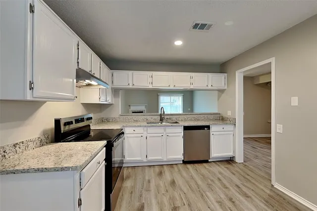 a kitchen with a sink stove and cabinets