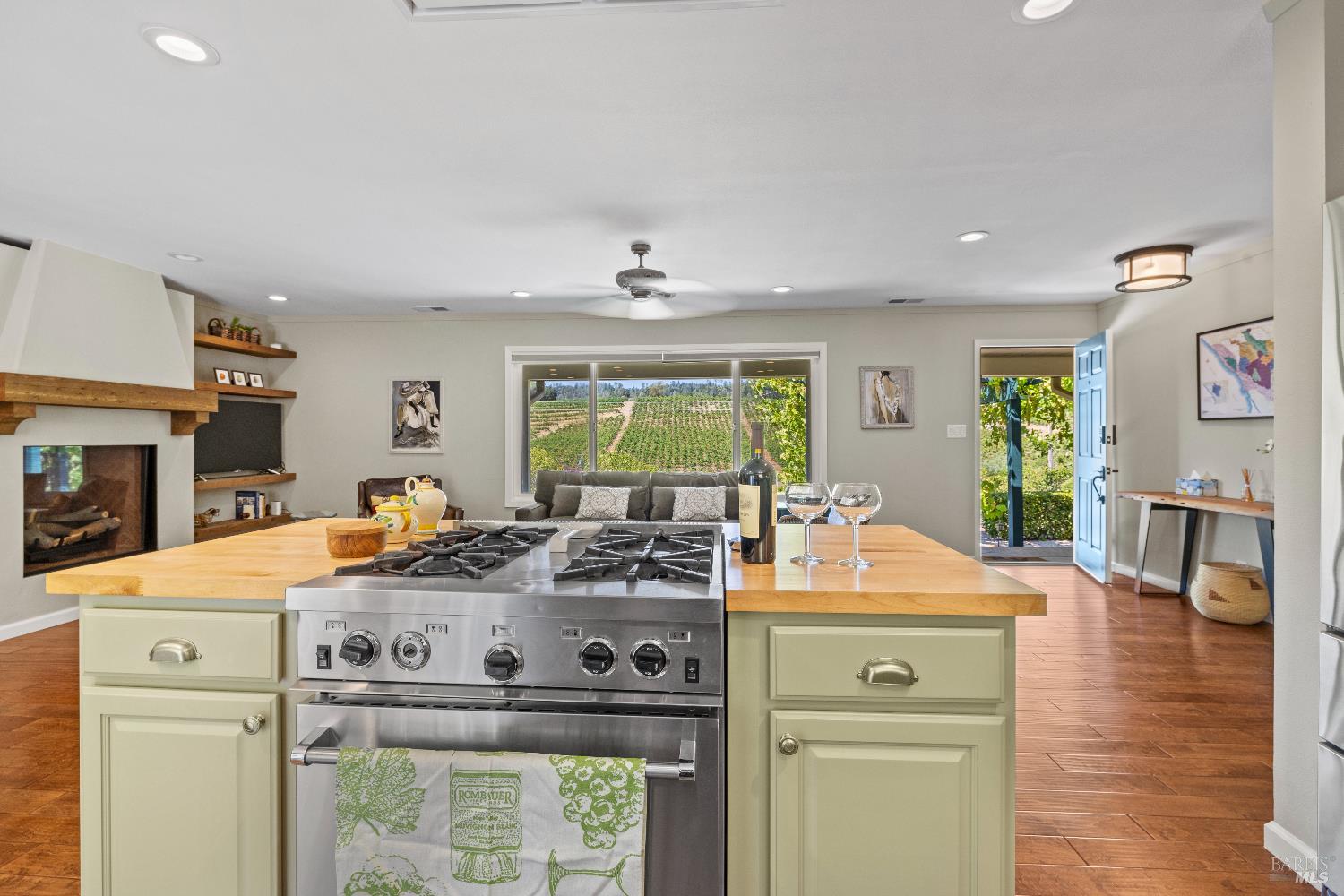 1389 Canyon Road Geyserville, CA 95441 - Photo 16 of 59 a view of a kitchen with kitchen island a stove a wooden floor and a dining table