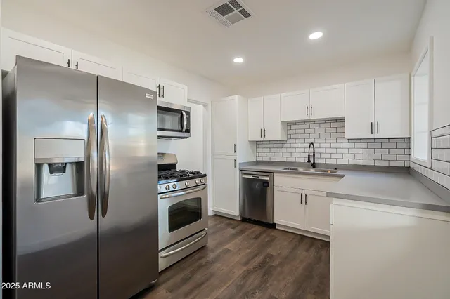 a kitchen with a refrigerator sink and stove top oven