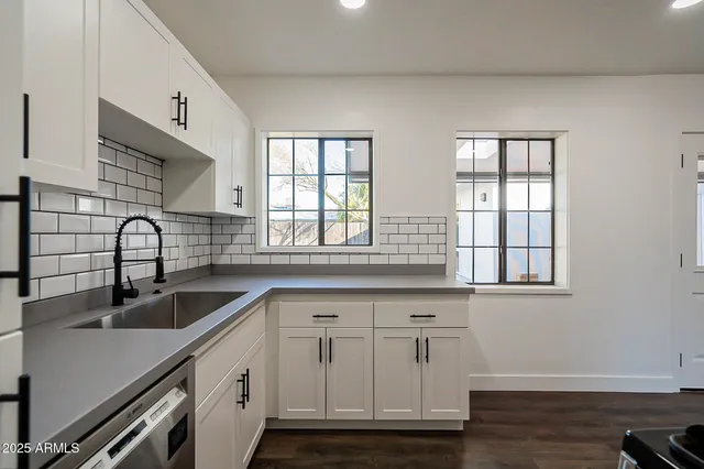 a kitchen with white cabinets and a sink