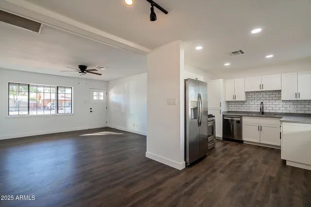 a kitchen with a refrigerator and white cabinets