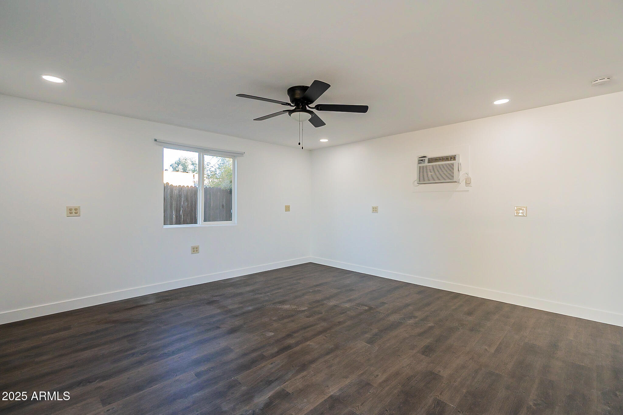 1316 East Lemon Street Tempe, AZ 85281 - Photo 21 of 43 an empty room with wooden floor chandelier fan and windows