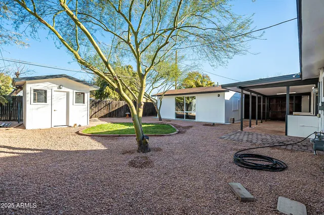a view of a house with backyard and tree