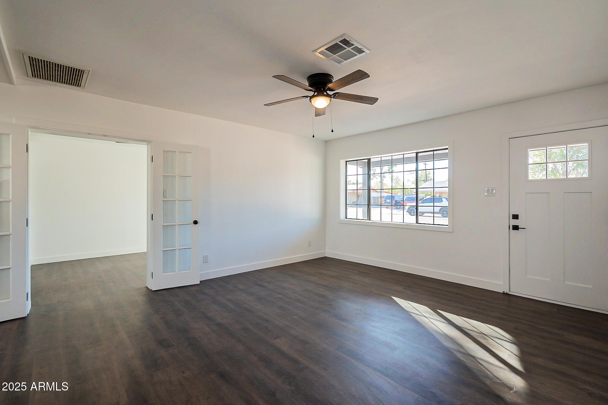 1316 East Lemon Street Tempe, AZ 85281 - Photo 4 of 43 a view of an empty room with wooden floor and a window