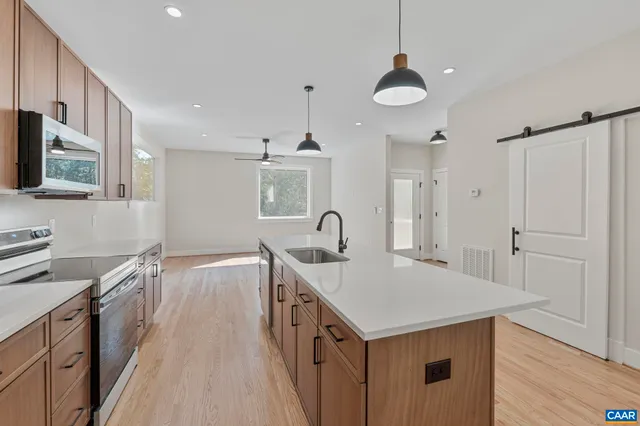 a bathroom with a toilet a sink a mirror and a window