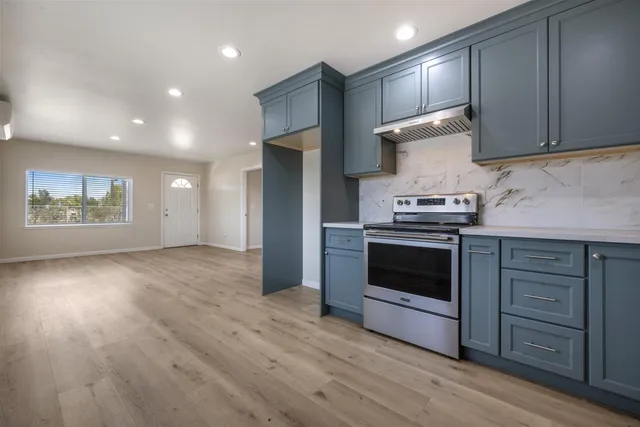 a kitchen with granite countertop wooden floors and stainless steel appliances