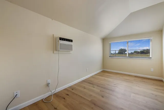 a view of a room with wooden floor and window