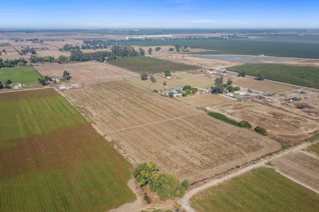 an aerial view of ocean and residential houses with outdoor space