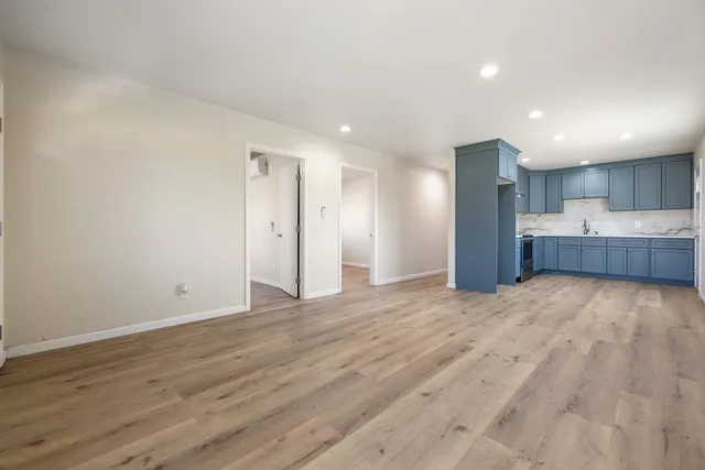 a view of kitchen with refrigerator and white cabinets