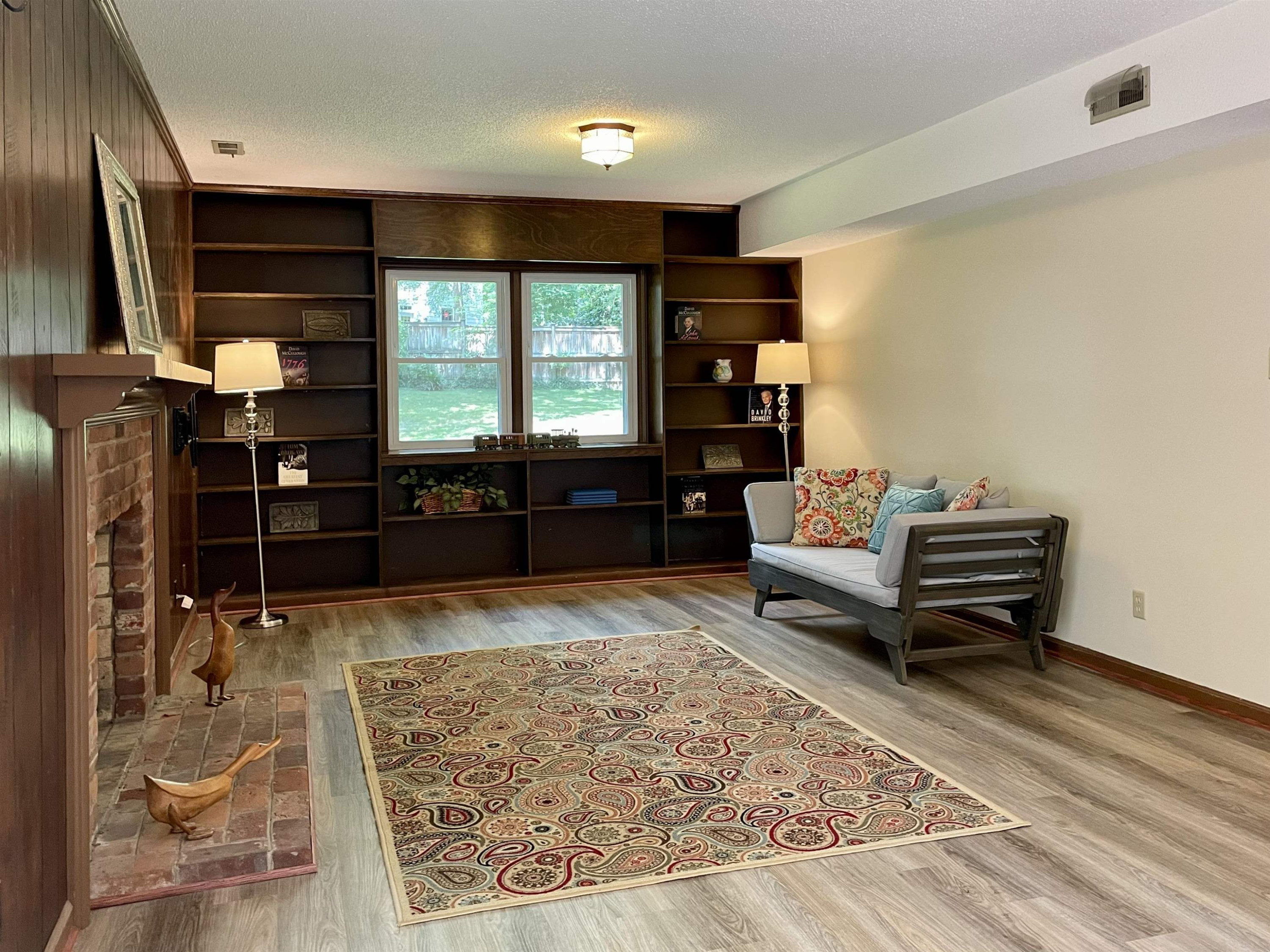 4506 Malvern Road Durham, NC 27707 - Photo 32 of 40 Large family room on lower level has new luxury vinyl plank flooring as does 4th bedroom. Store your books and more in the full wall bookshelves. Family Room