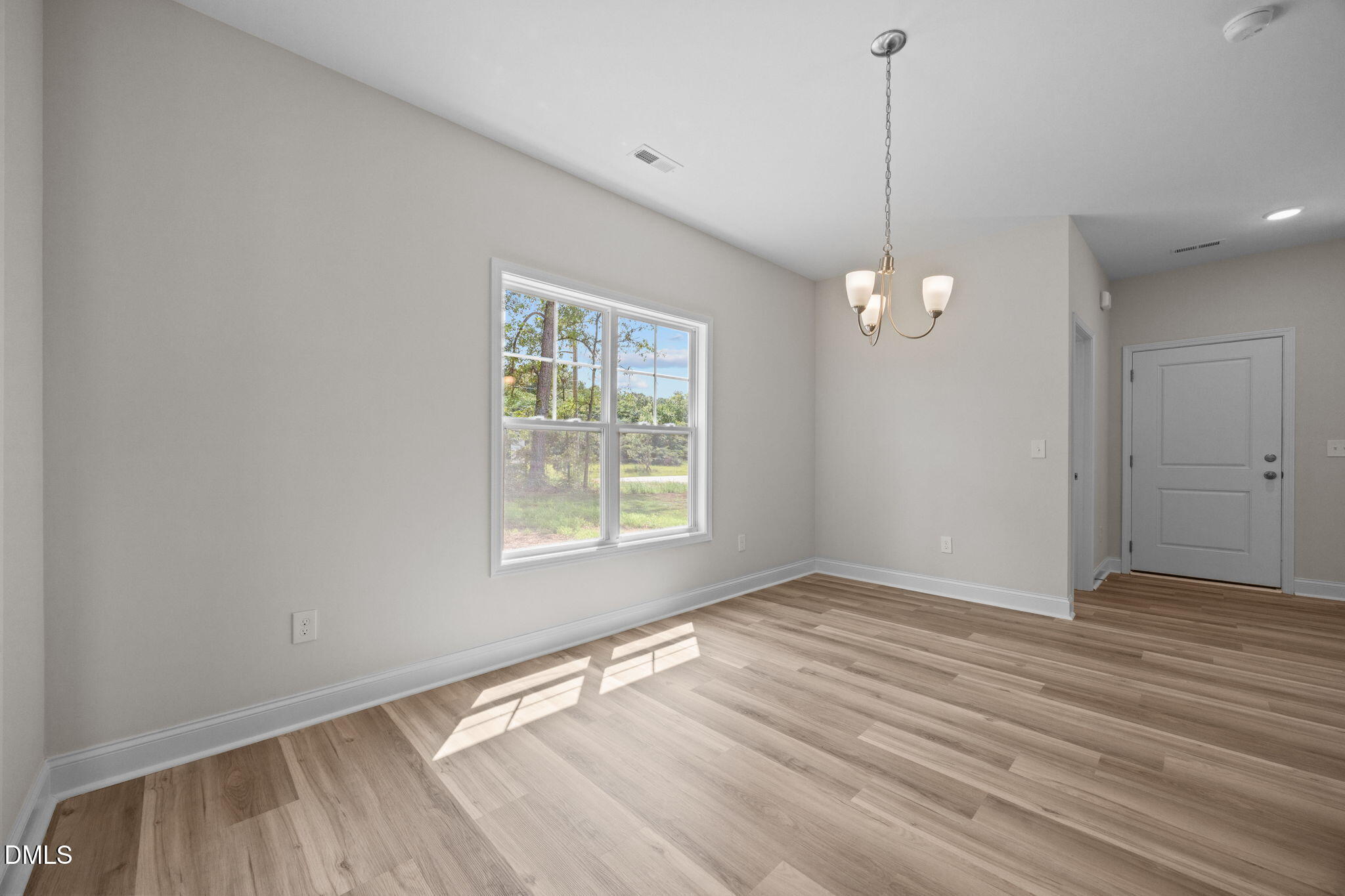 205 Regis Lane, Unit 11 Coats, NC 27521 - Photo 8 of 37 a view of an empty room with wooden floor and a window