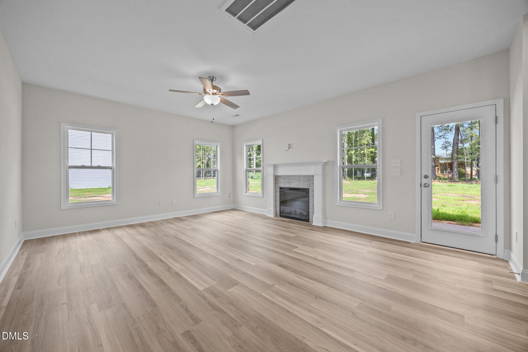 205 Regis Lane, Unit 11 Coats, NC 27521 - Photo 9 of 37 an empty room with windows chandelier and fireplace